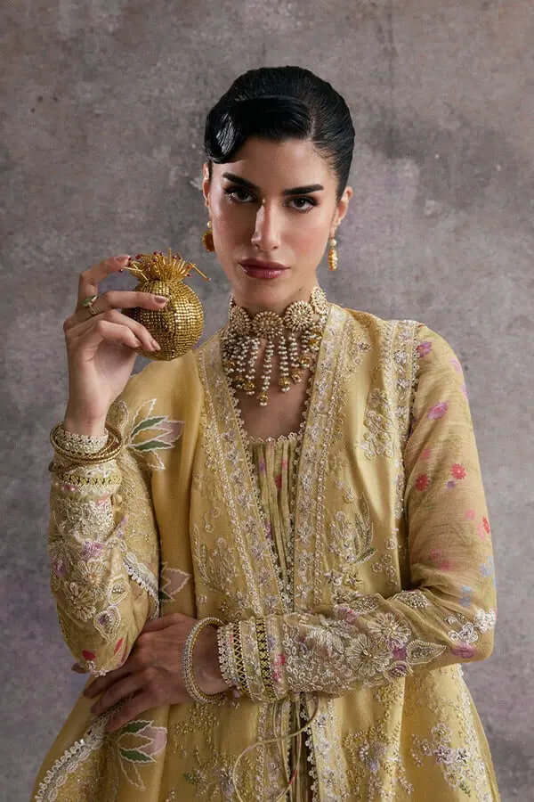 Urah straight lemon yellow silk gown with embroidery, model holding intricate accessory, showcasing time management elegance.