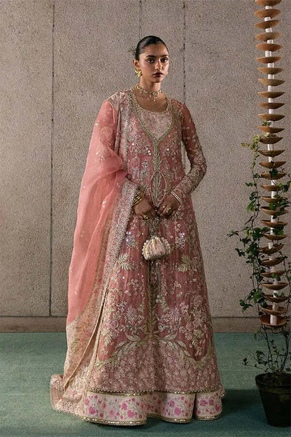 Model wearing Novara, a rose coral embroidered pishwas with matching sharara and organza dupatta, featuring tassel details.