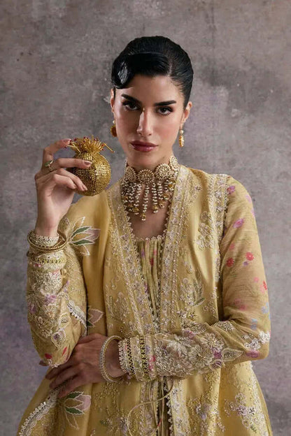 Urah straight lemon yellow silk gown with embroidery, model holding intricate accessory, showcasing time management elegance.
