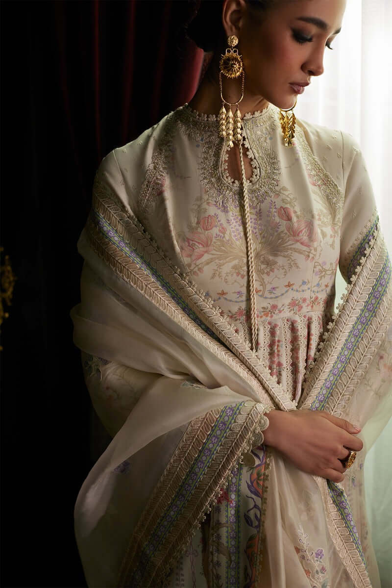 Elegant Safira pishwas with floral prints, paired with an embroidered dupatta and stylish earrings.