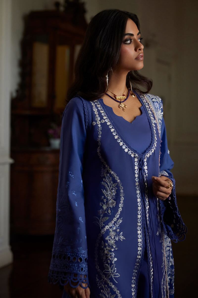Elegant woman in deep periwinkle Eslem dress with intricate embroidery and lace accents, perfect for special occasions.