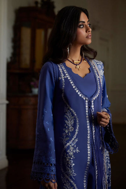 Elegant woman in deep periwinkle Eslem dress with intricate embroidery and lace accents, perfect for special occasions.